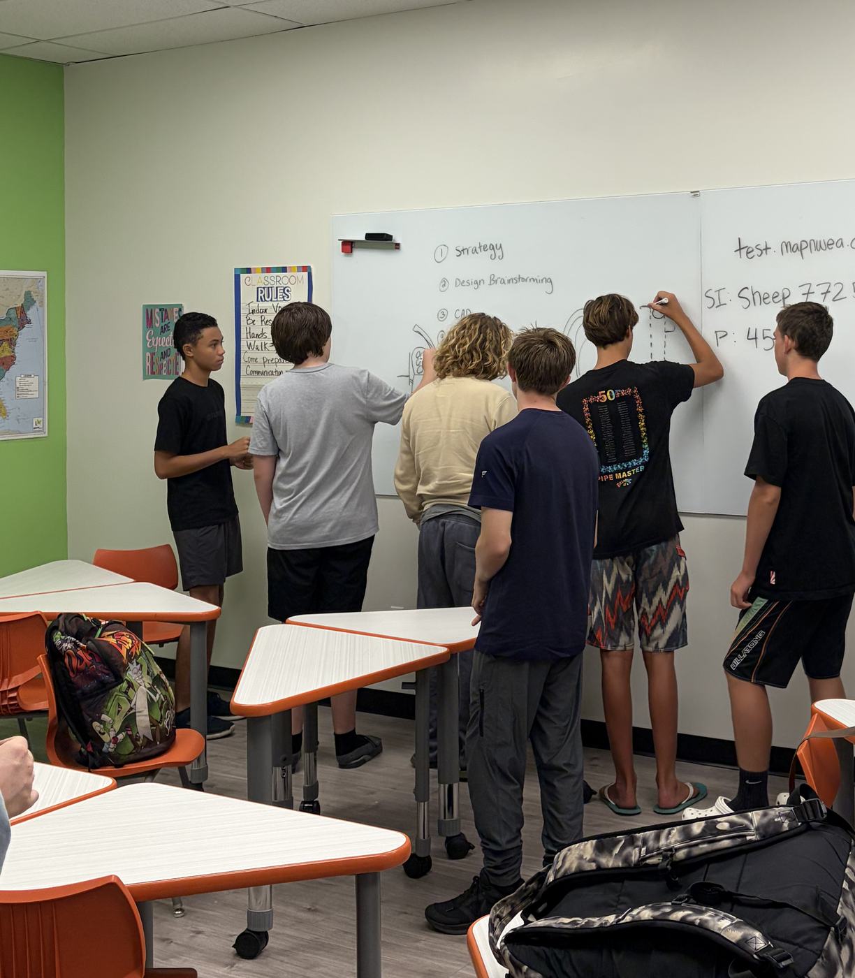 Team members writing ideas on a classroom whiteboard