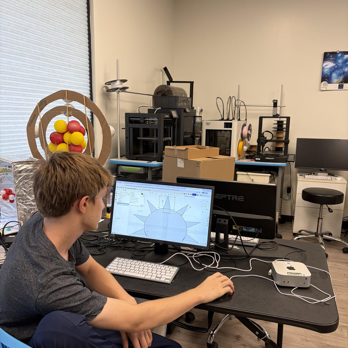 A team member working in CAD software at a desktop computer