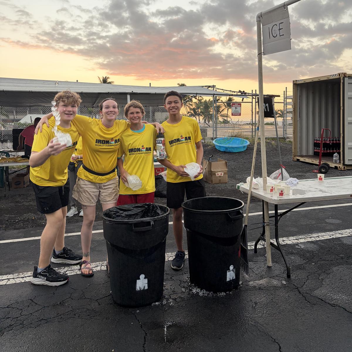 Four team members at an IRONMAN ice station at sunset