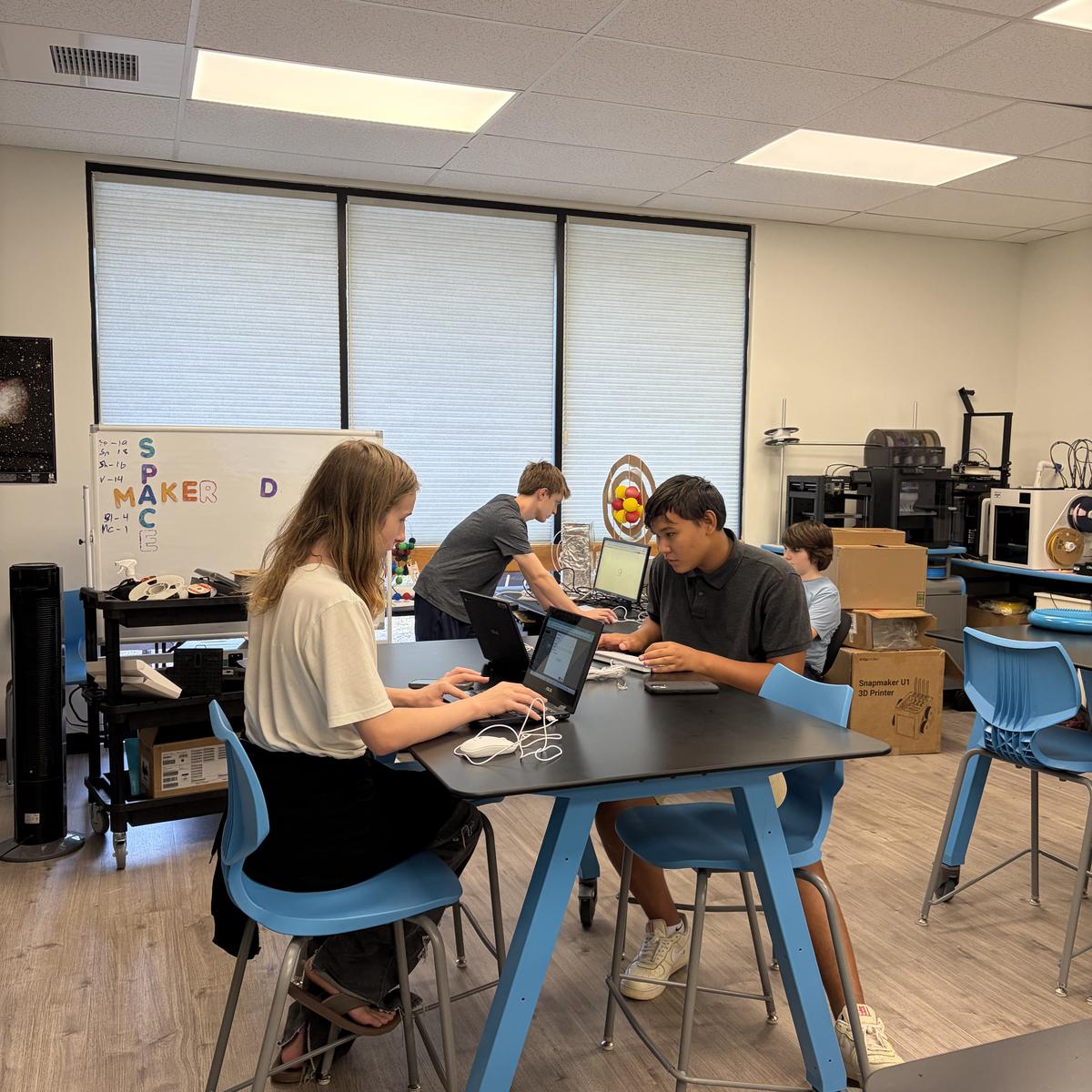 Team members working on laptops around a shared table